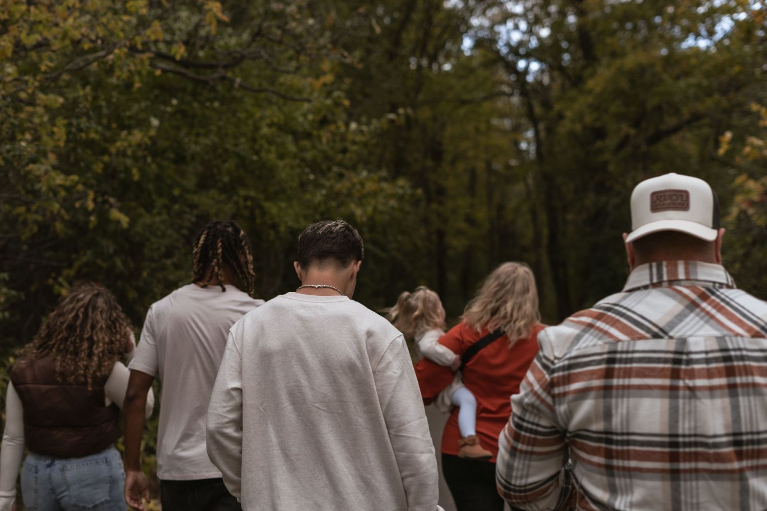 Group walking together on an autumn trail through the woods.