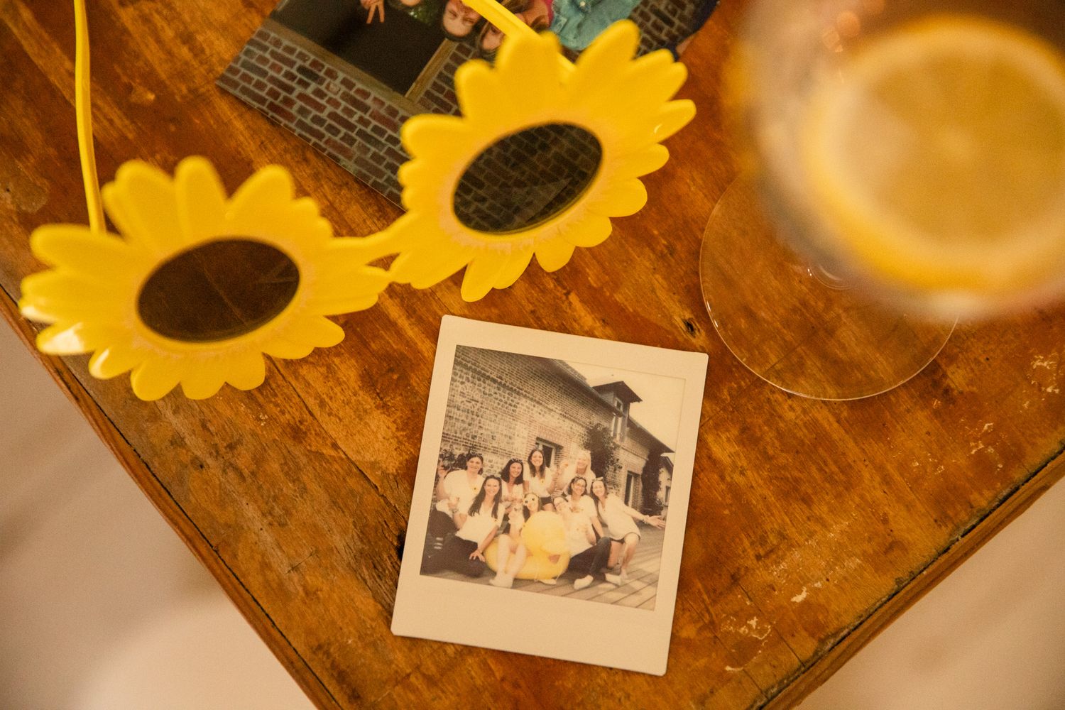 Vintage photographs and sunflowers arranged on a rustic wooden table create a nostalgic display.