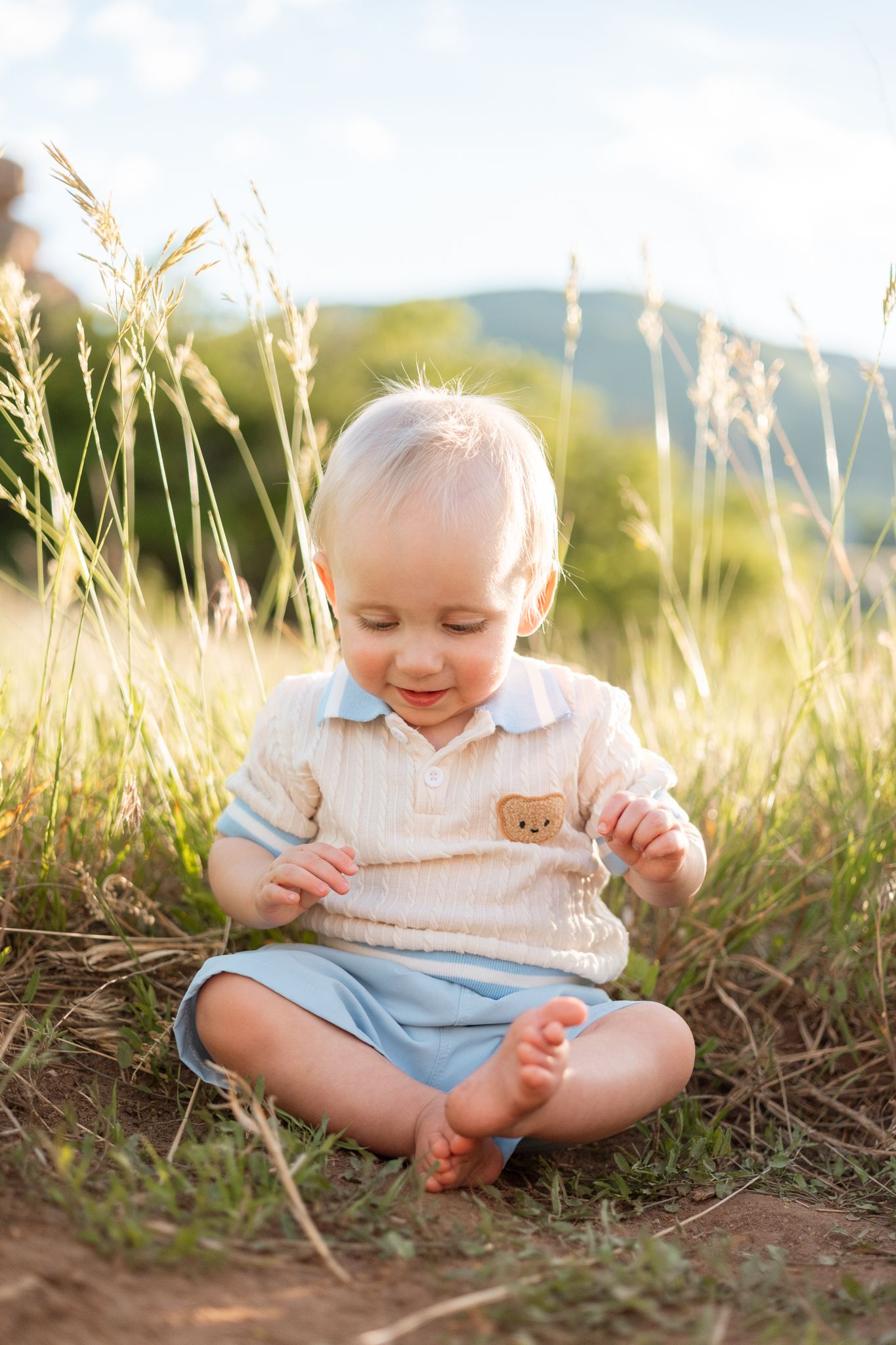 One year old boy sitting in tall grasses at South Valley Park in Littleton, Colorado.