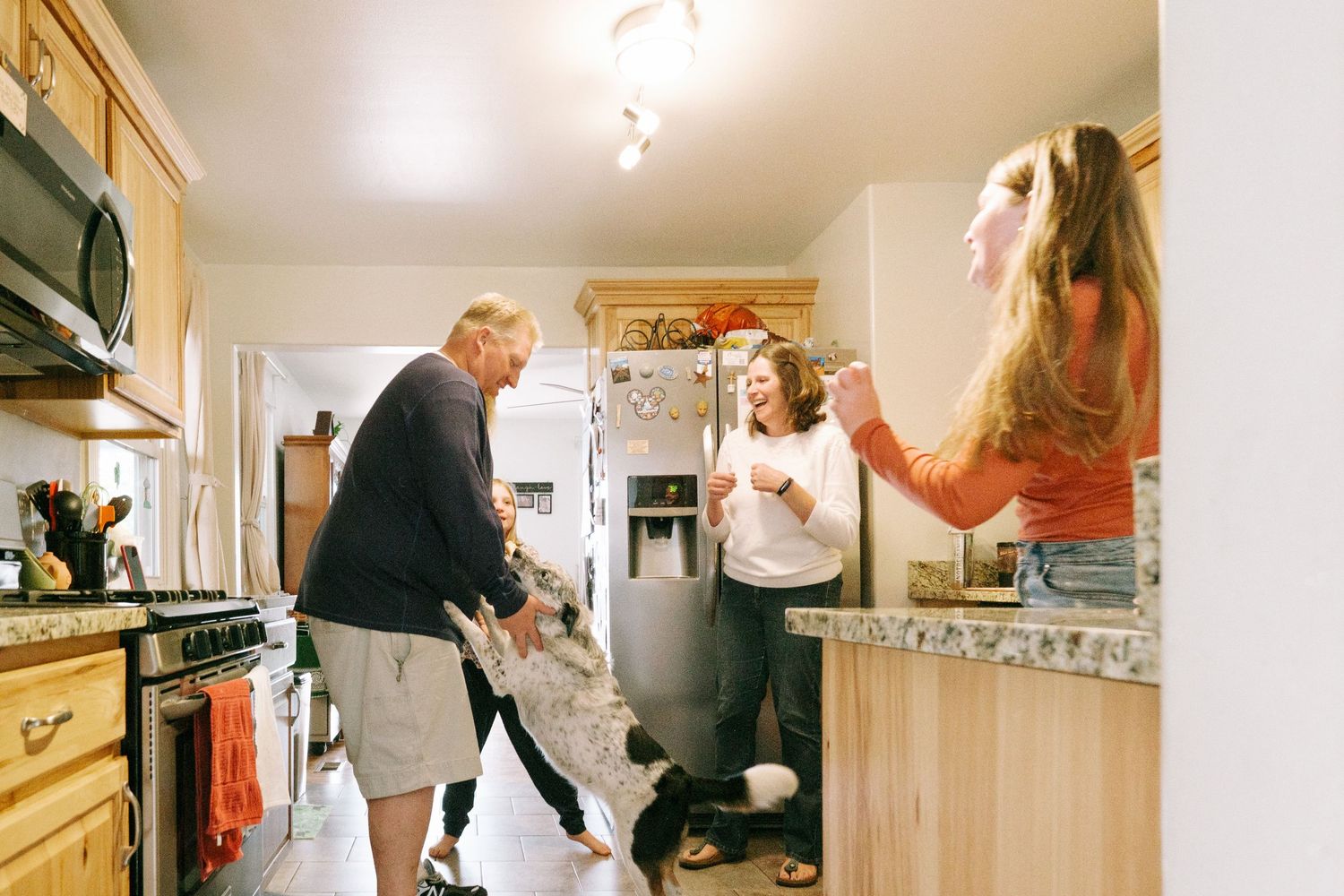 Denver family having a playful dance party in kitchen.