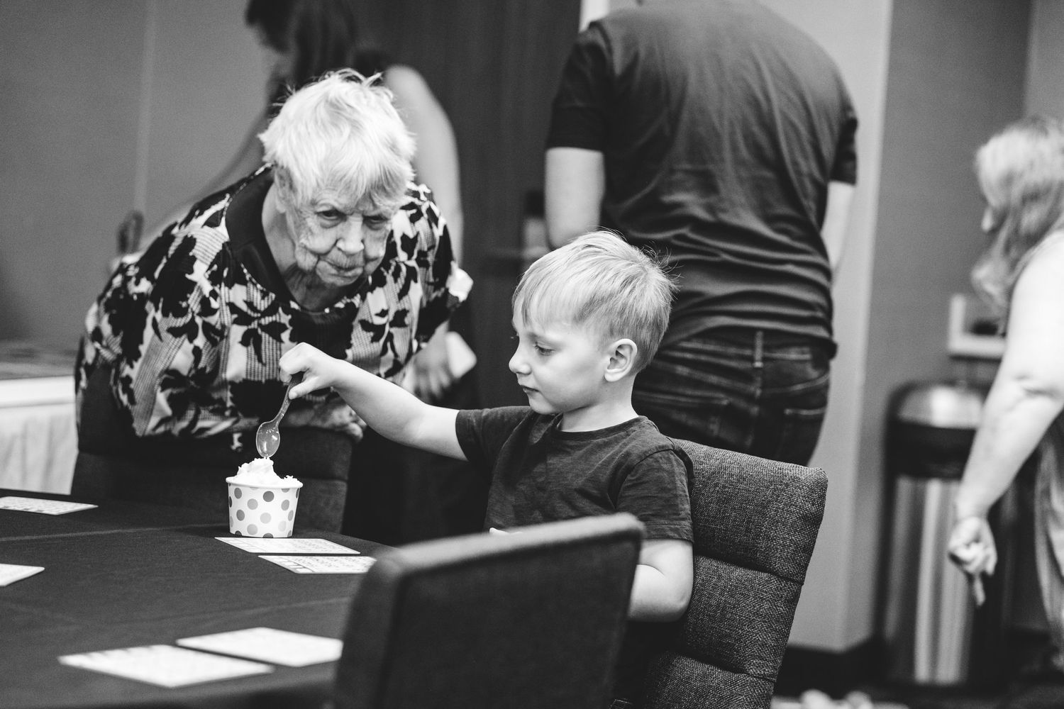 Grandma peering down toward young great grandson.