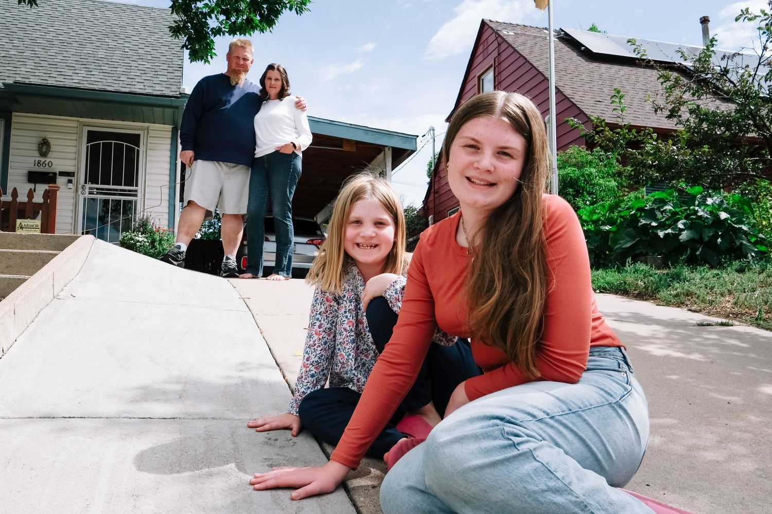 In-home Denver family photography session,  sisters sitting next to handprints in cement.