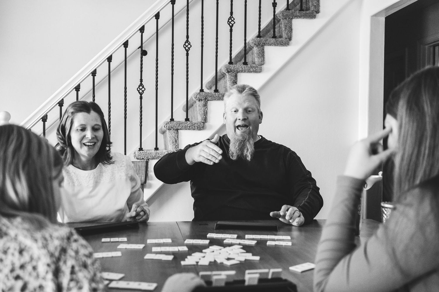In-home Denver family photography session,  family of four playing rumikub at dining table.