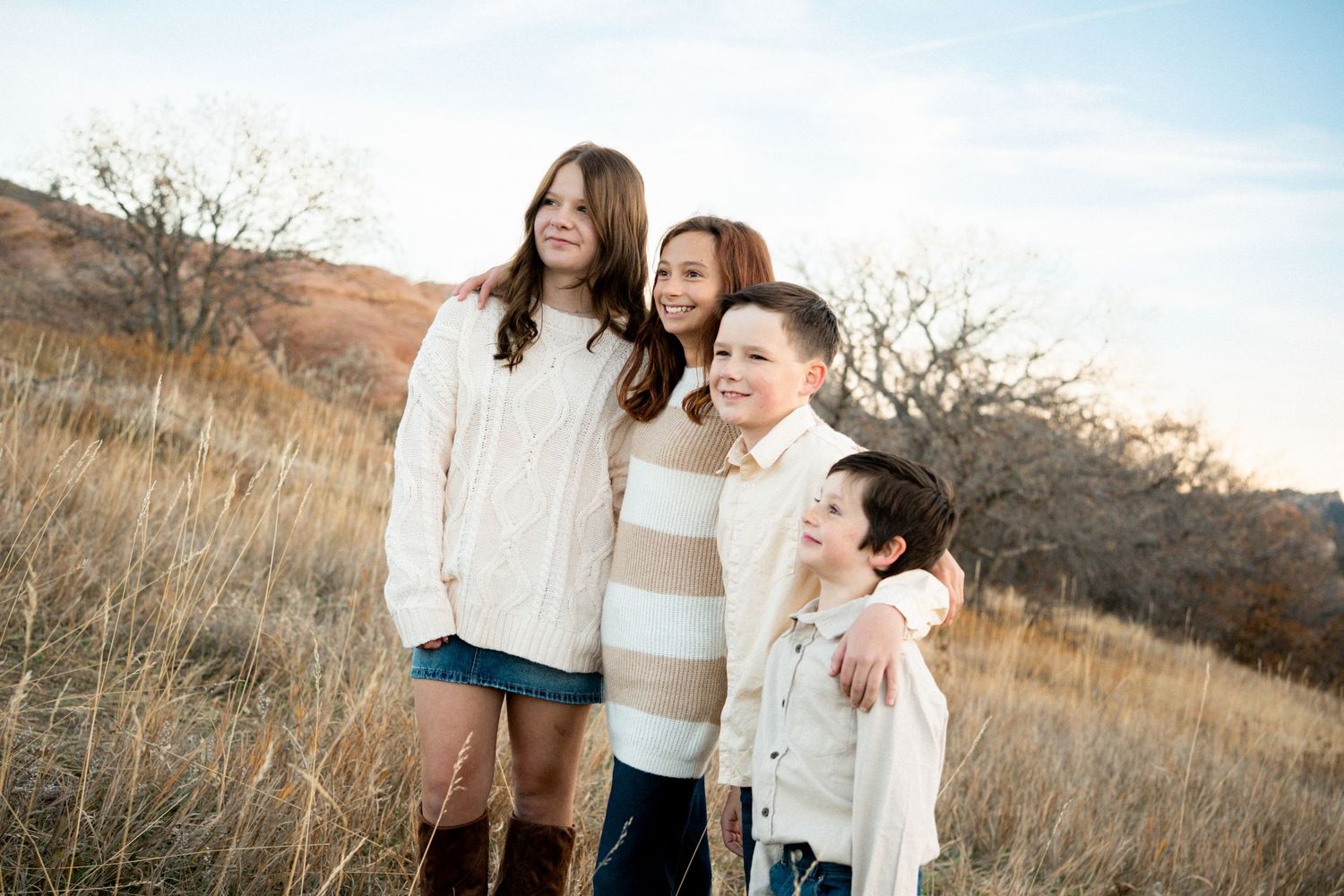 Portrait of blended siblings standing together, smiling.