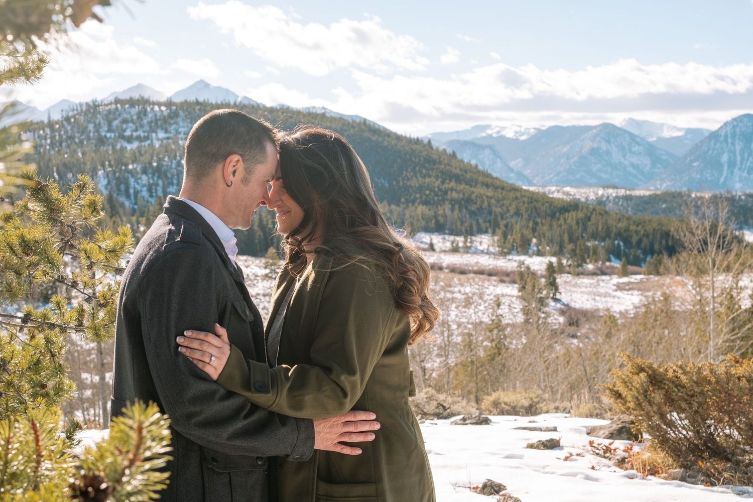 Couple embracing, touching foreheads, near Breckenridge, Colorado during engagement photo session.
