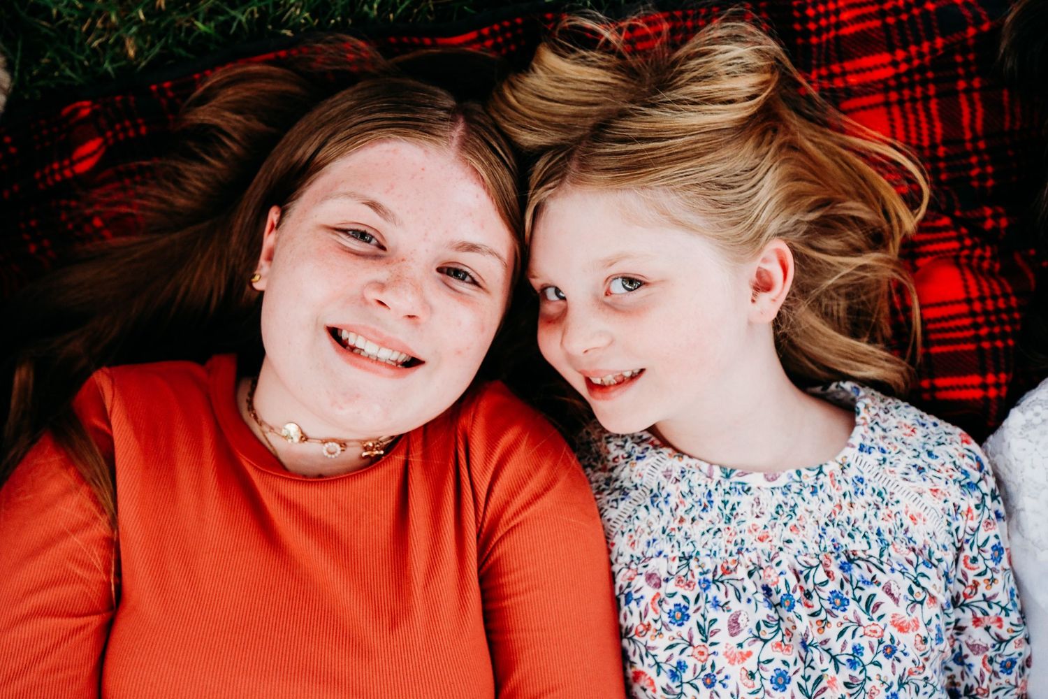 In-home Denver family photography session,  sisters snuggling on picnic blanket.