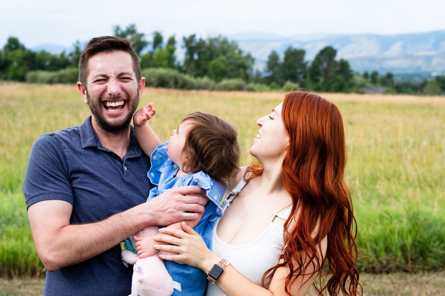 Playful portrait of uncle, aunt and toddler daughter.