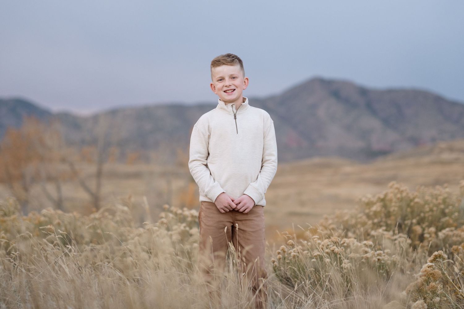 Portrait of boy during blue hour at Bear Creek Lake Park in Lakewood, foothills in the background.