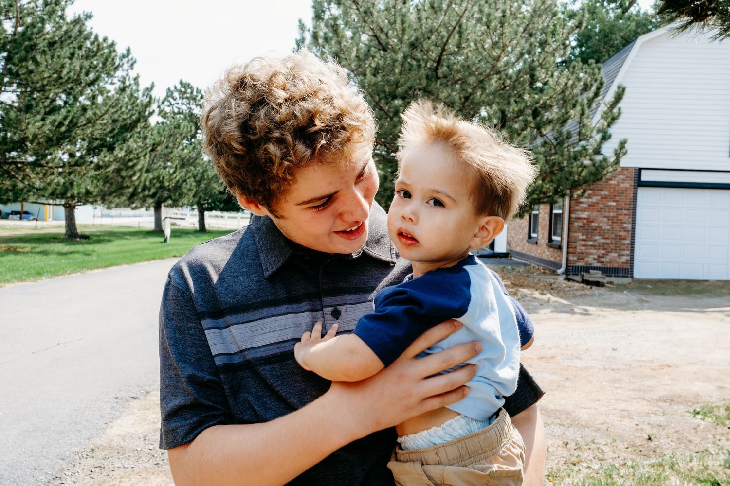Teenage brother holding toddler brother.
