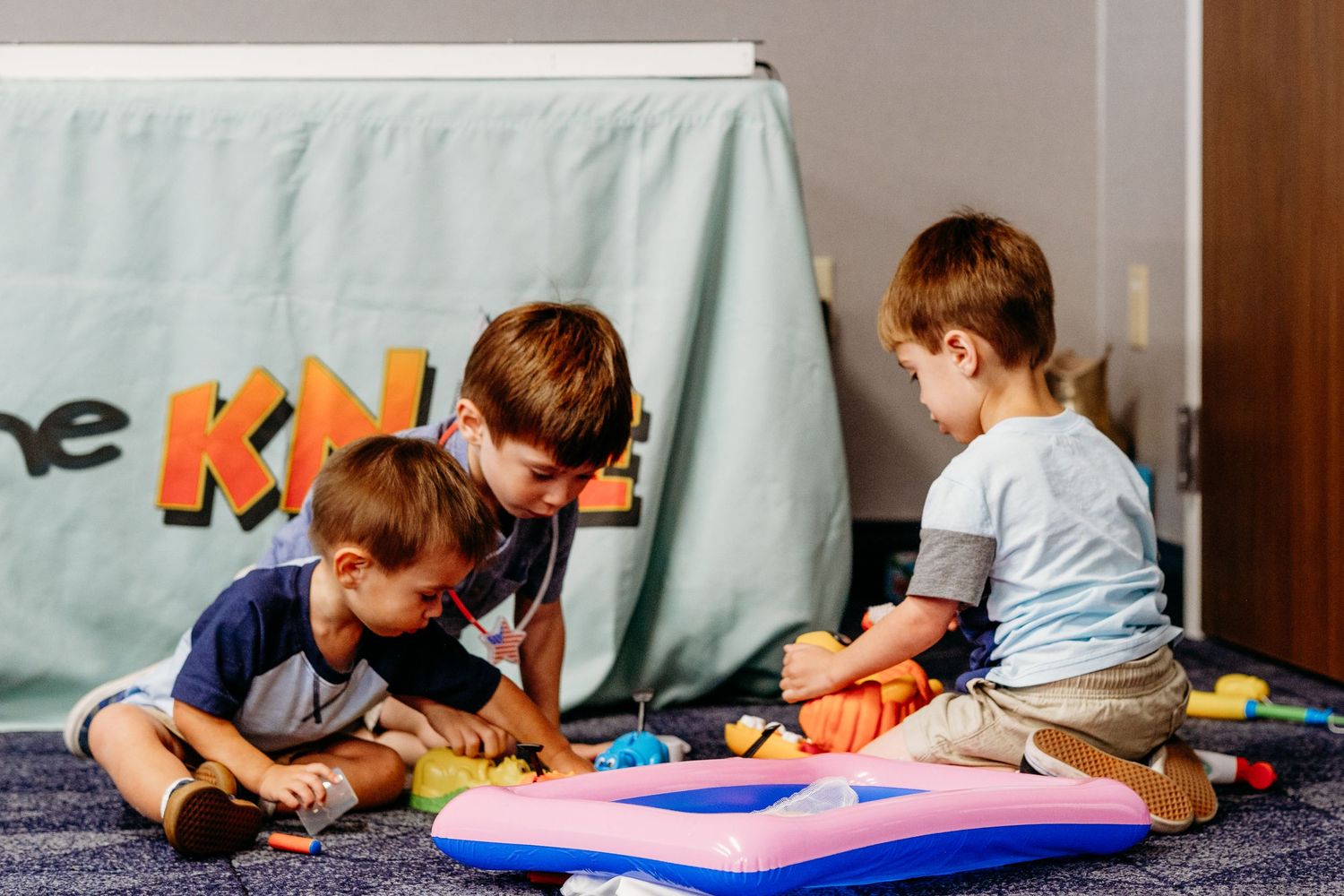 Brothers playing with toys at Grandma's 90th birthday party in documentary event photography session.
