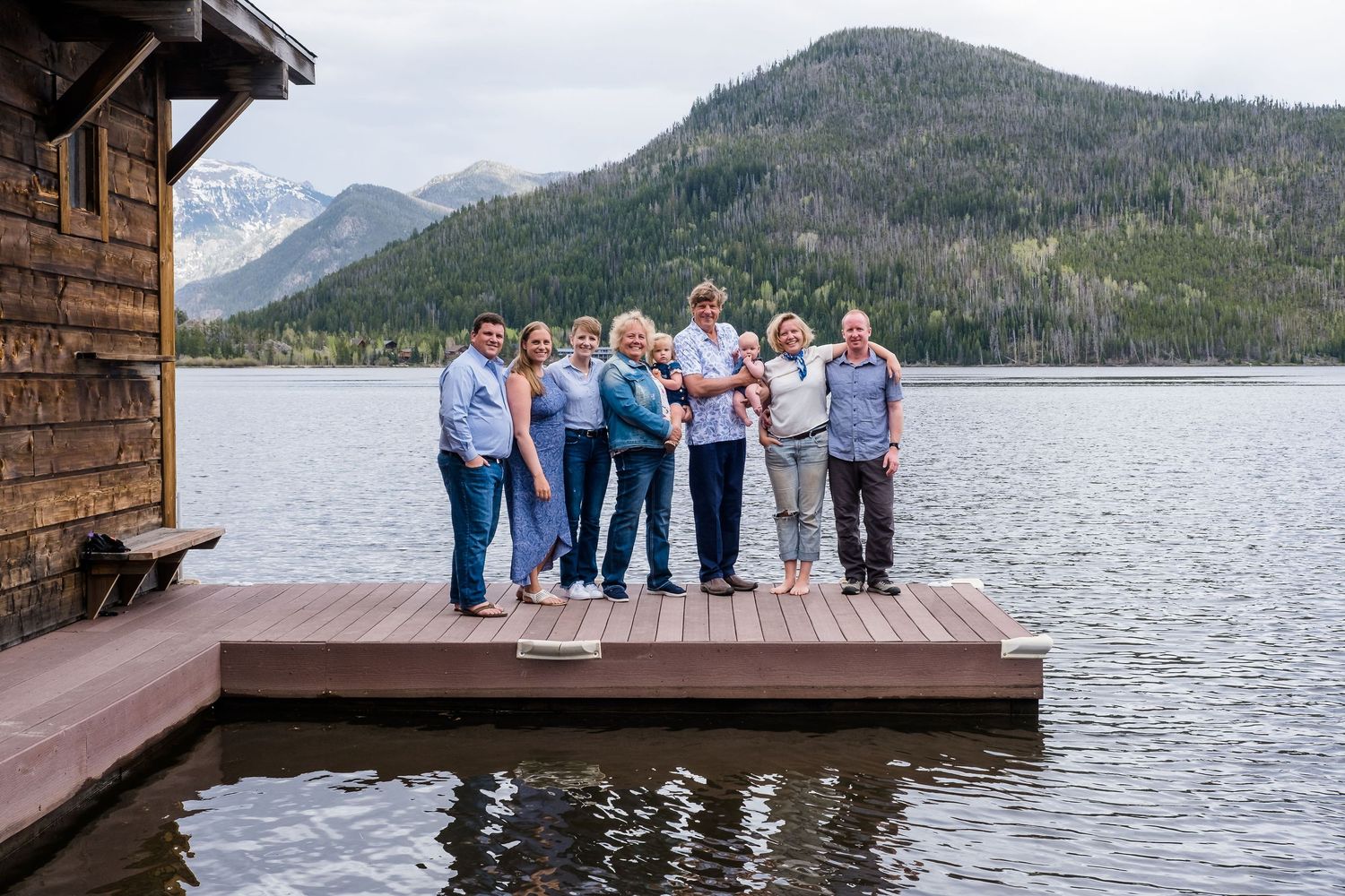 Multi generation family portrait of 7 adults and two children standing on dock off of Shadow Mountain Lake in the mountains of Colorado.