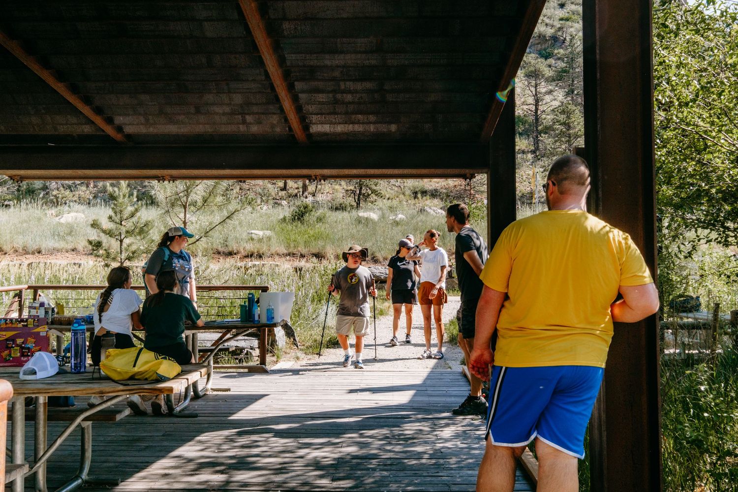 Hikers joining under covered picnic area off of Big Easy Trailhead in Golden, Colorado.