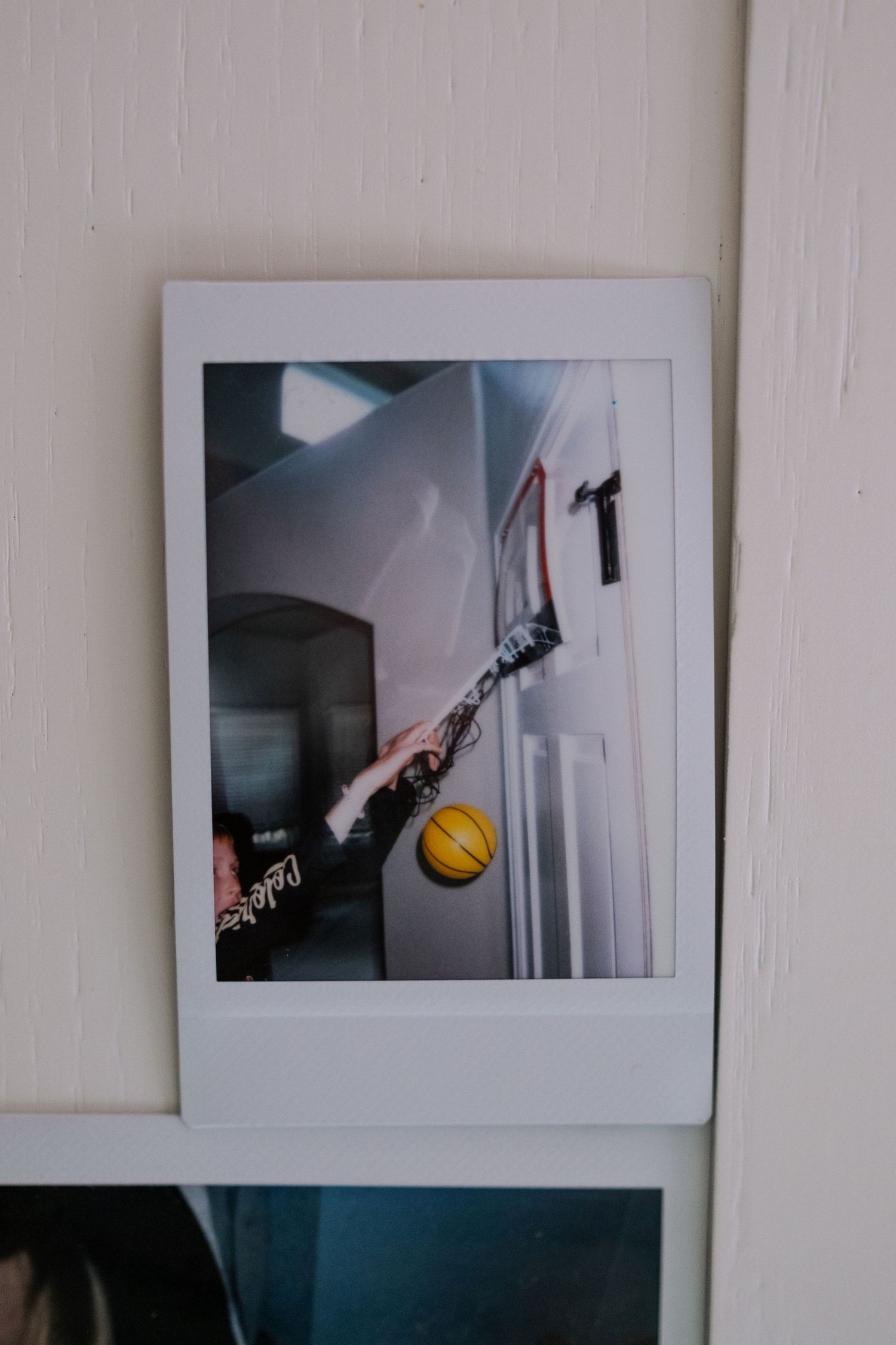 Project 365 - polaroid of boy playing basketball in hallway.