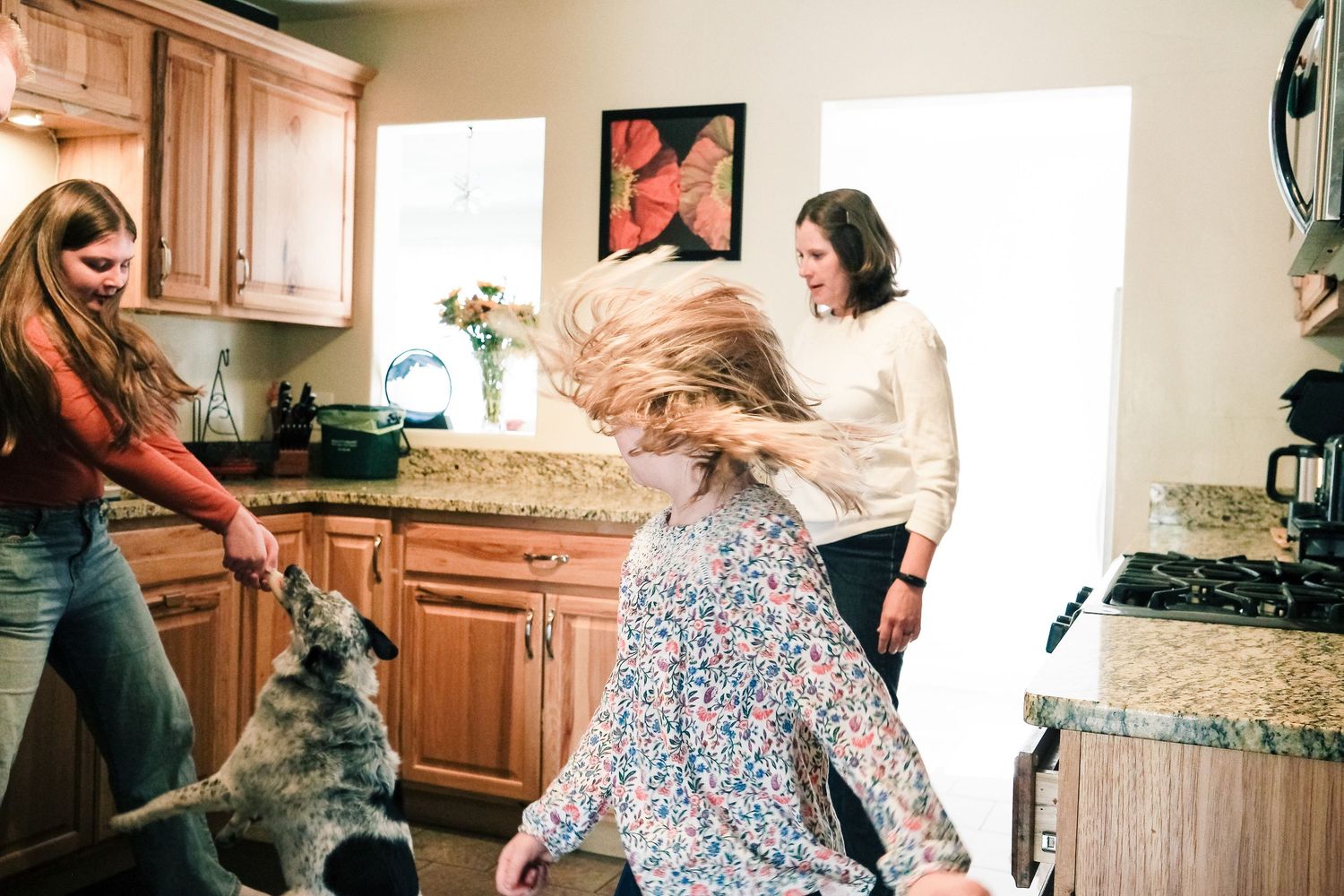 Denver family having a playful dance party in kitchen.