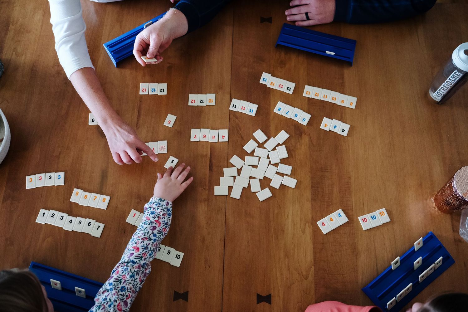 In-home Denver family photography session,  family of four playing rumikub at dining table.