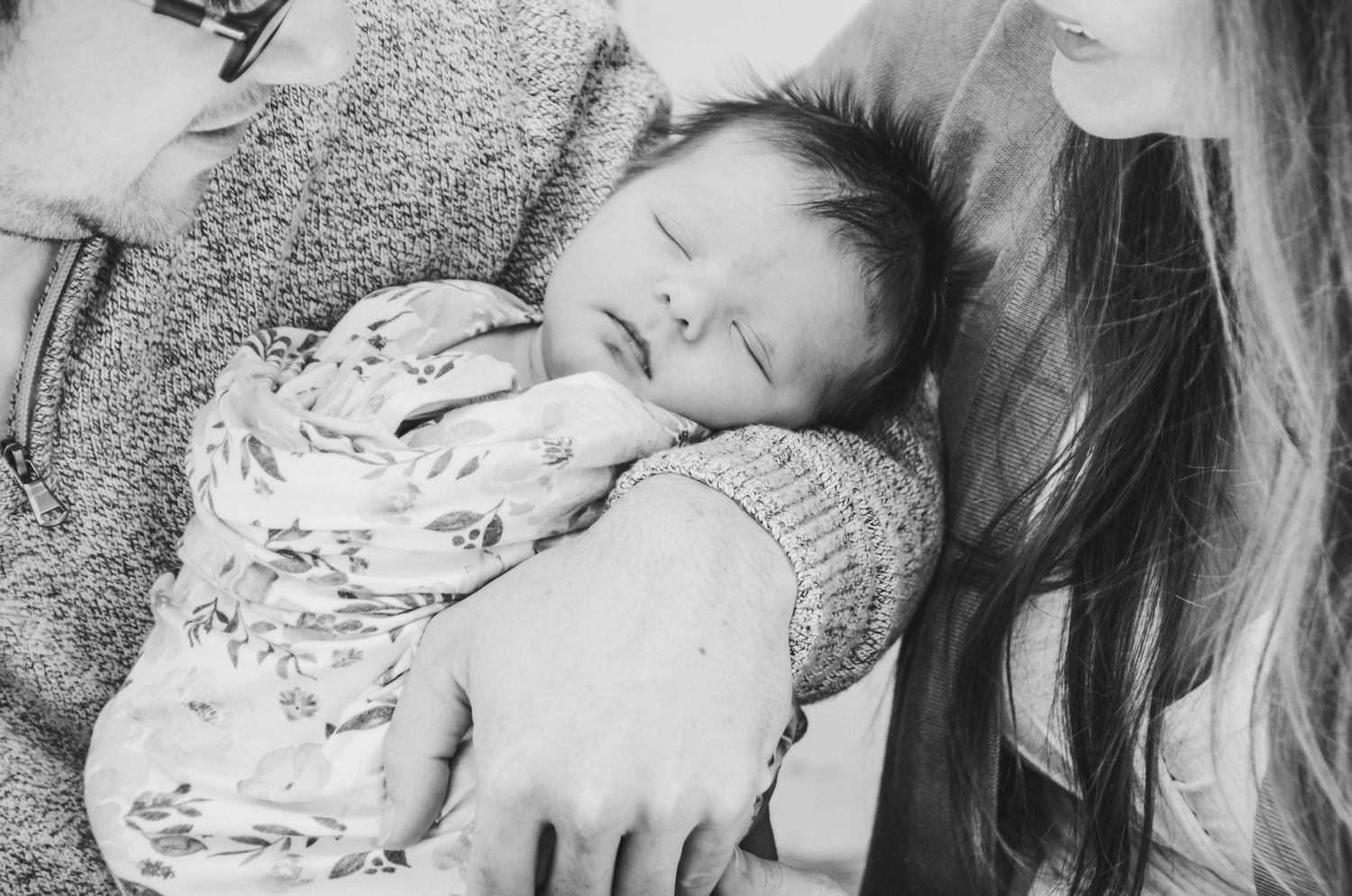 Closeup of baby sleeping very peacefully in father's arms.