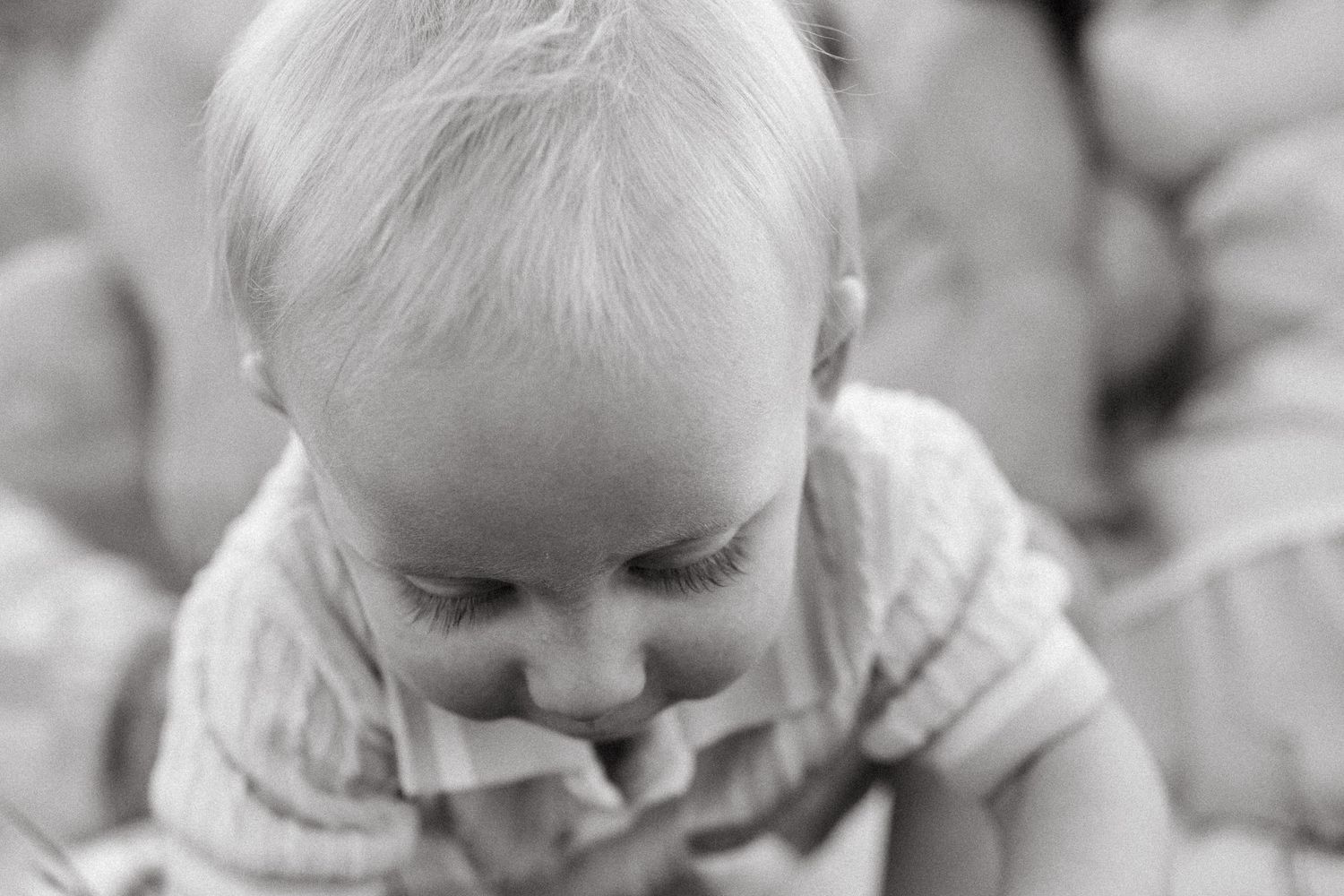 Black and white portrait of one year old boy's eye lashes as he looks toward the ground.
