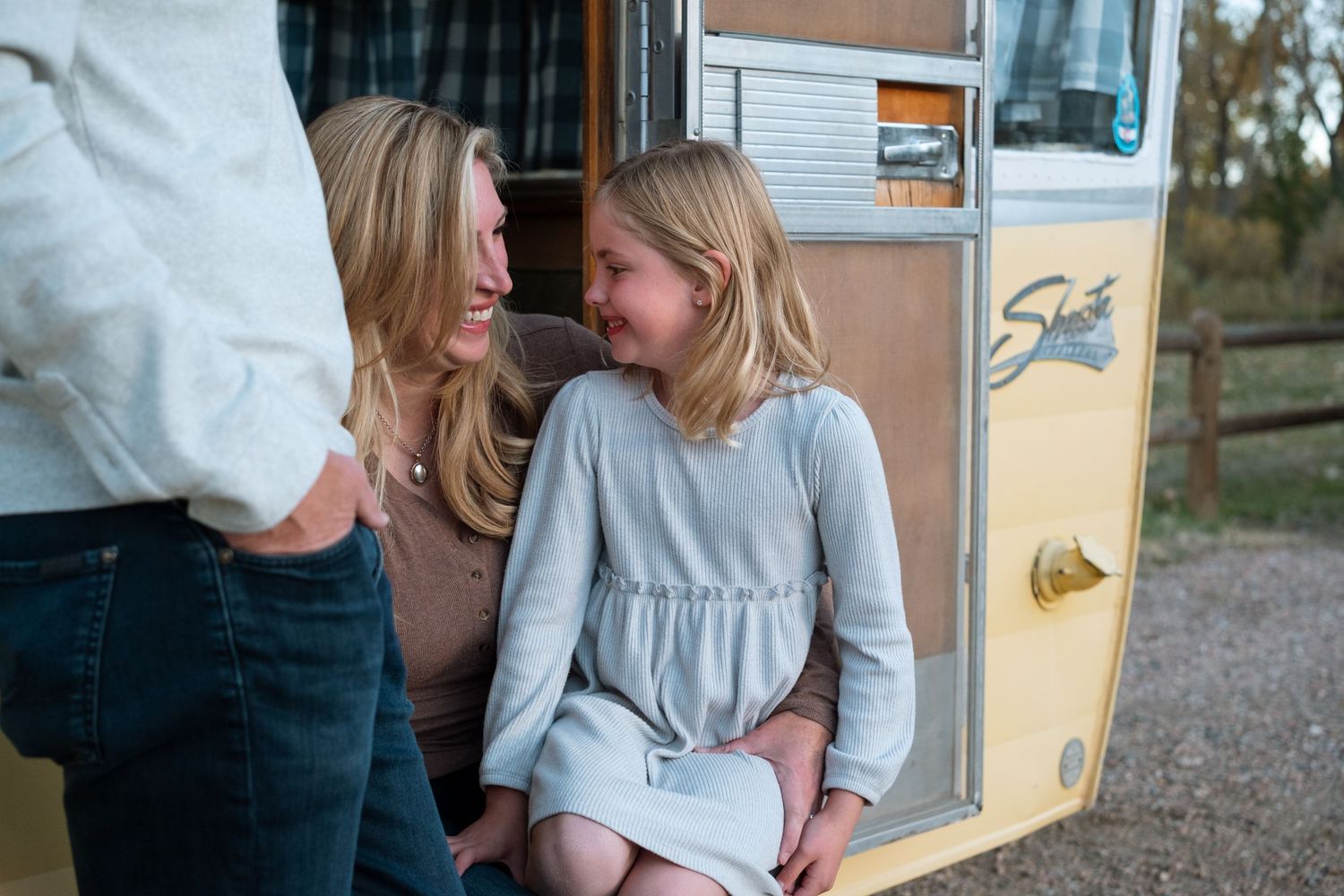 Close up of mother and daughter in front of vintage Shasta trailer at Bear Creek Lake Park in Lakewood, Colorado.