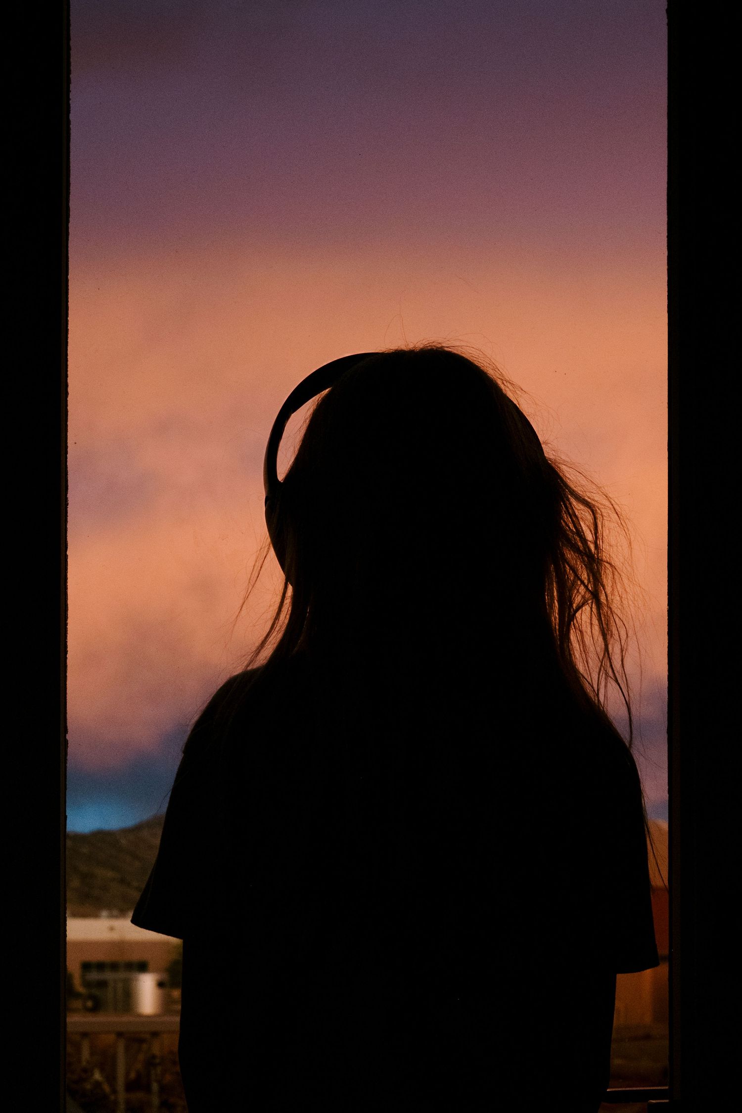 Project 365 - silhouette of girl looking out window at pink sunset.