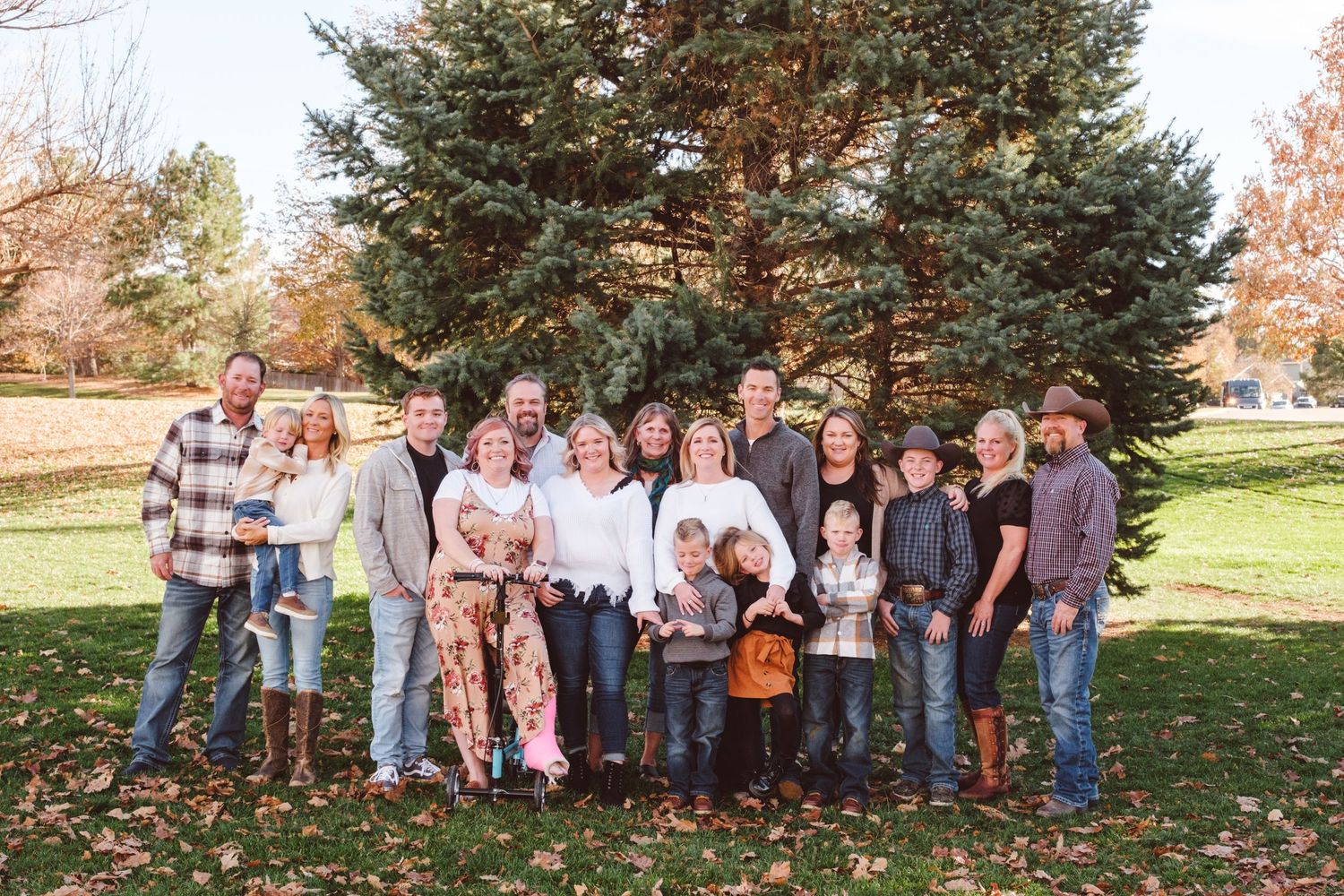 Extended family standing together, all smiling, in park in Centennial, Colorado.  Group includes grandmother, adult children and grandkids.