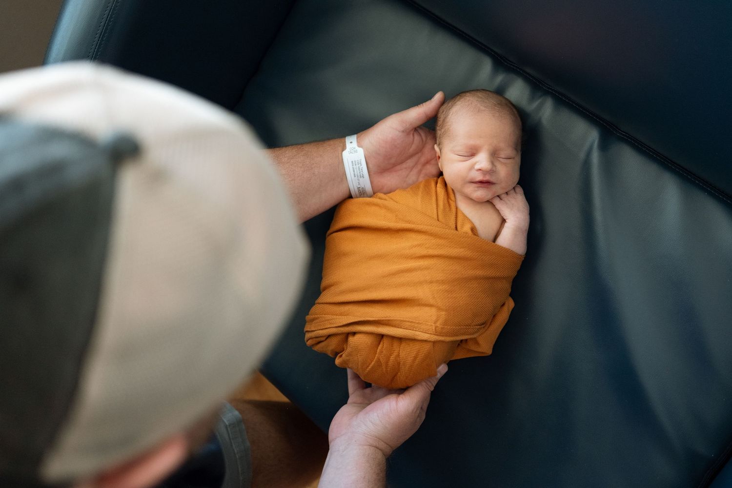Dad carefully setting swaddled baby down.