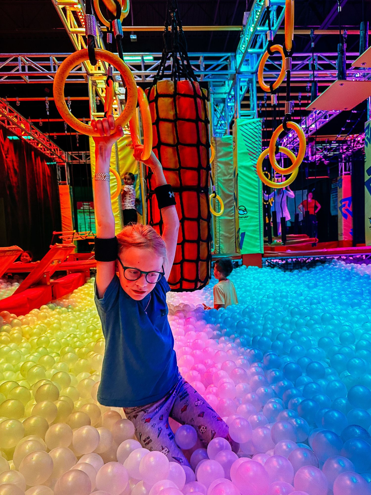 Child playing in ball pit at trampoline park.