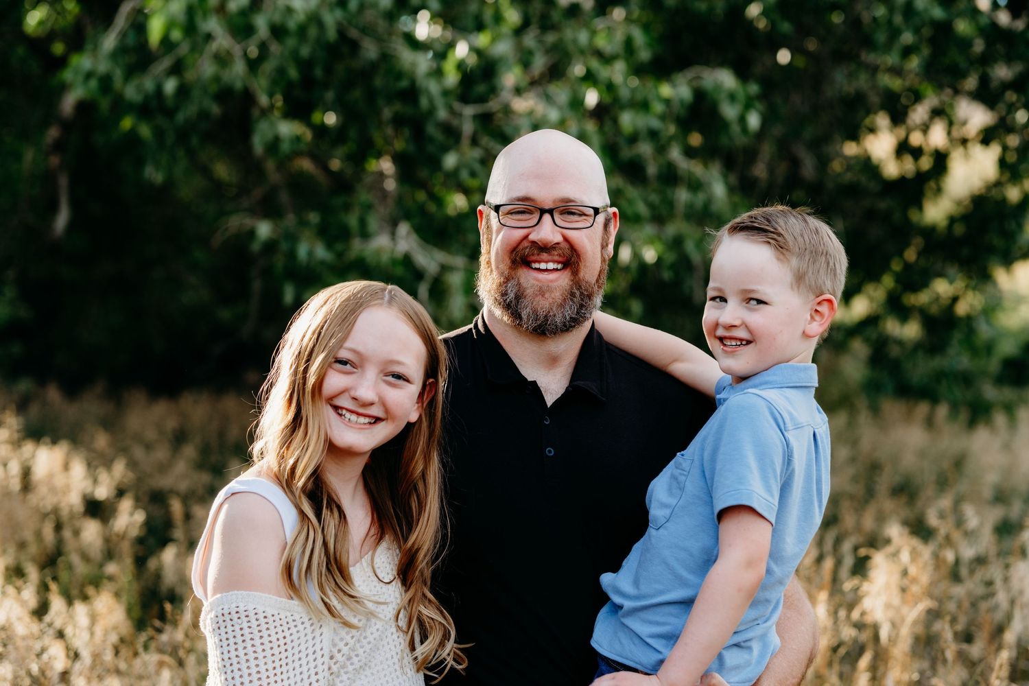 Father smiling with daughter and son at Hildebrand park in Littleton, Colorado.