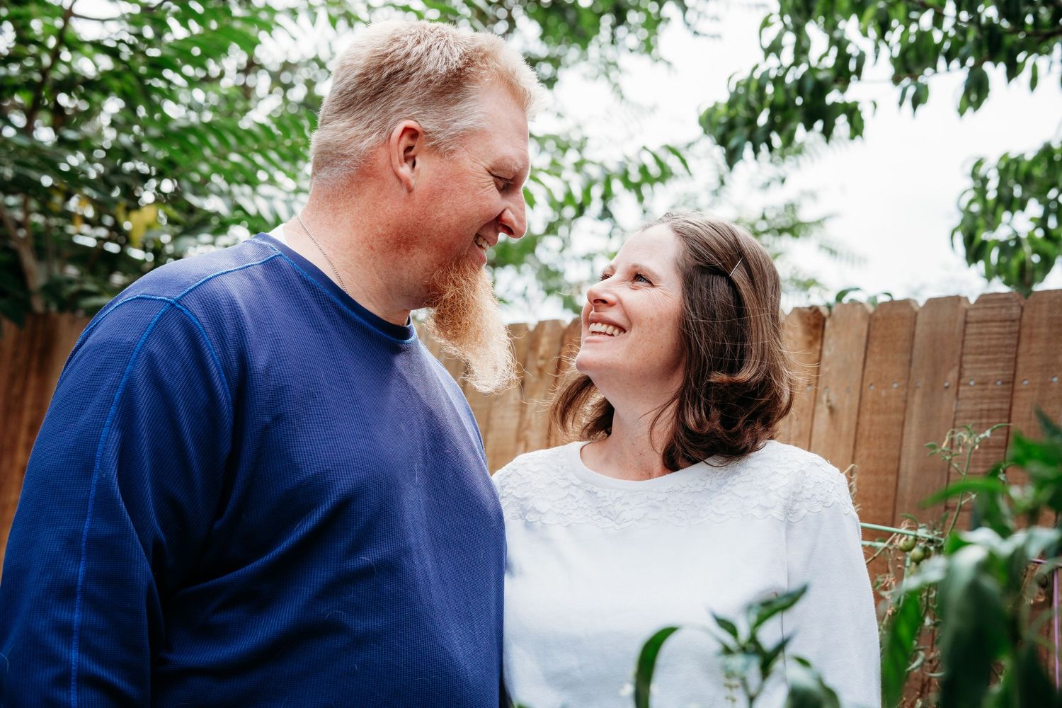 In-home Denver family photography session,  couple looking at one another in backyard.