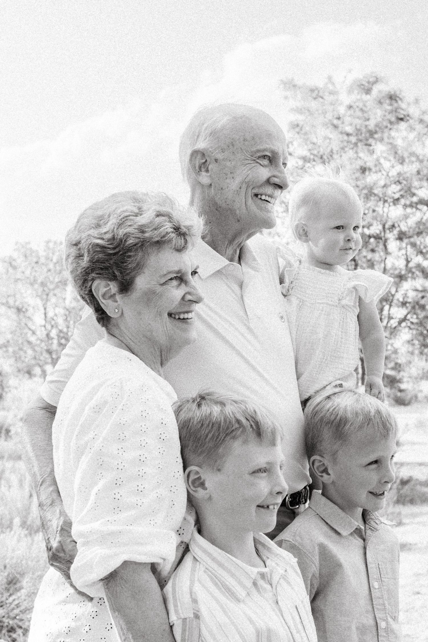 Black and white portrait of grandparents standing with two grandsons and one granddaughter.