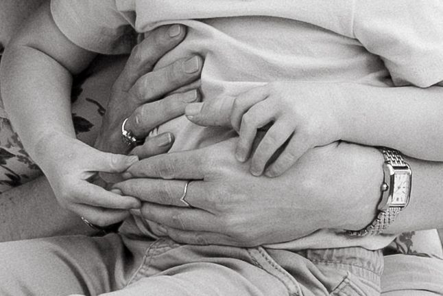 Close up of mother and toddler's hands.