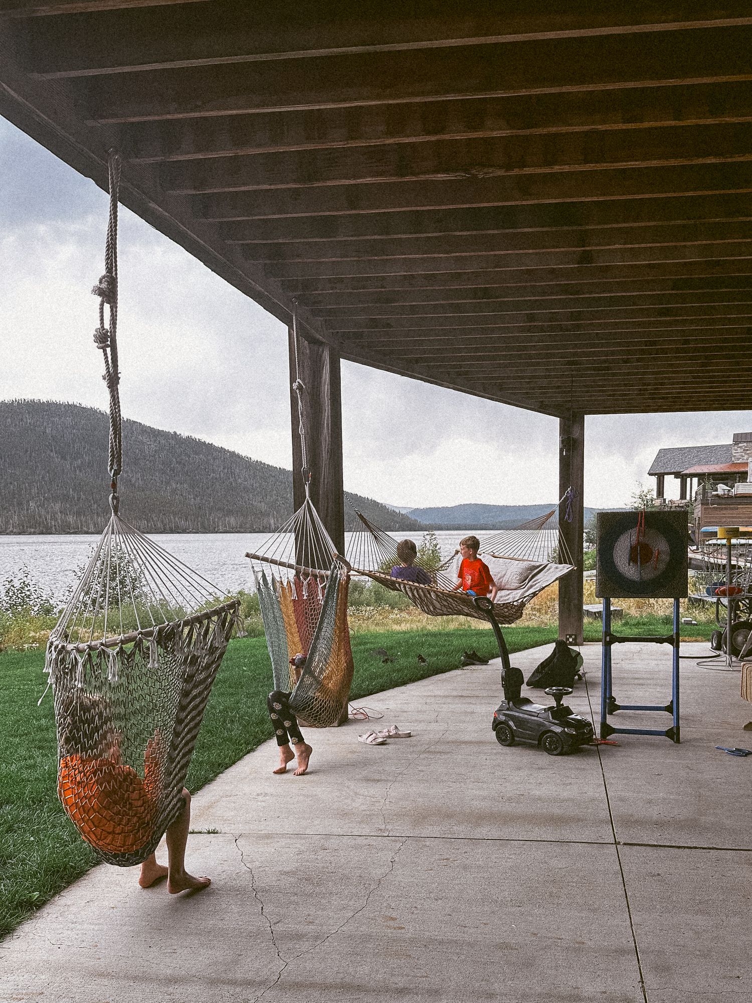 Project 365 photo - children playing in hammocks under porch at mountain cabin.