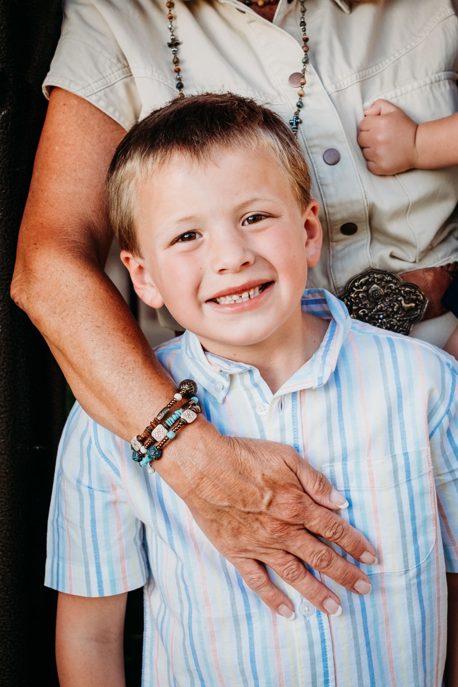 Close up of young boy being embraced by grandma.