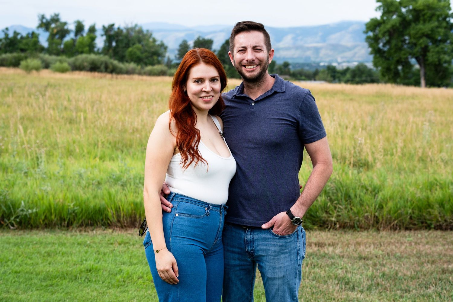 Couple standing close together, smiling, at Majestic View Park.