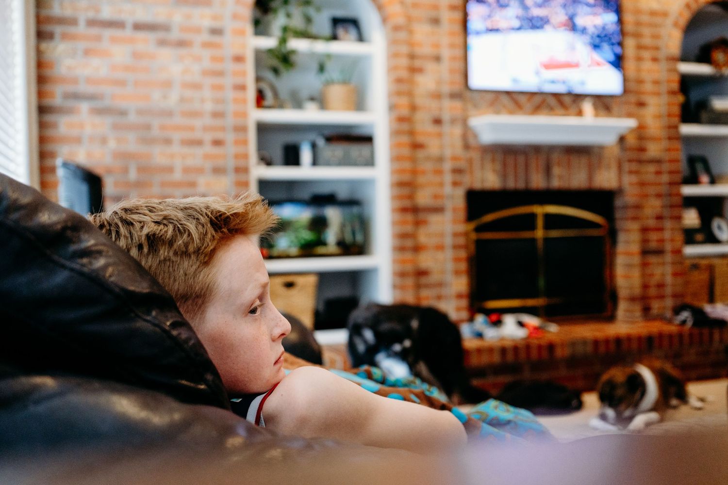 Child watching basketball on TV in living room.