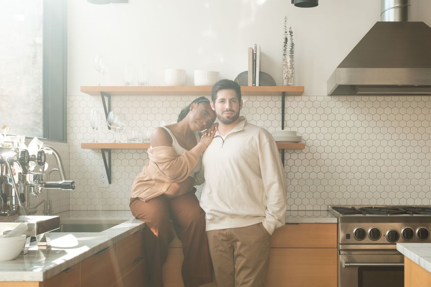 Couple sitting in modern kitchen during maternity photography session near Denver, Colorado.
