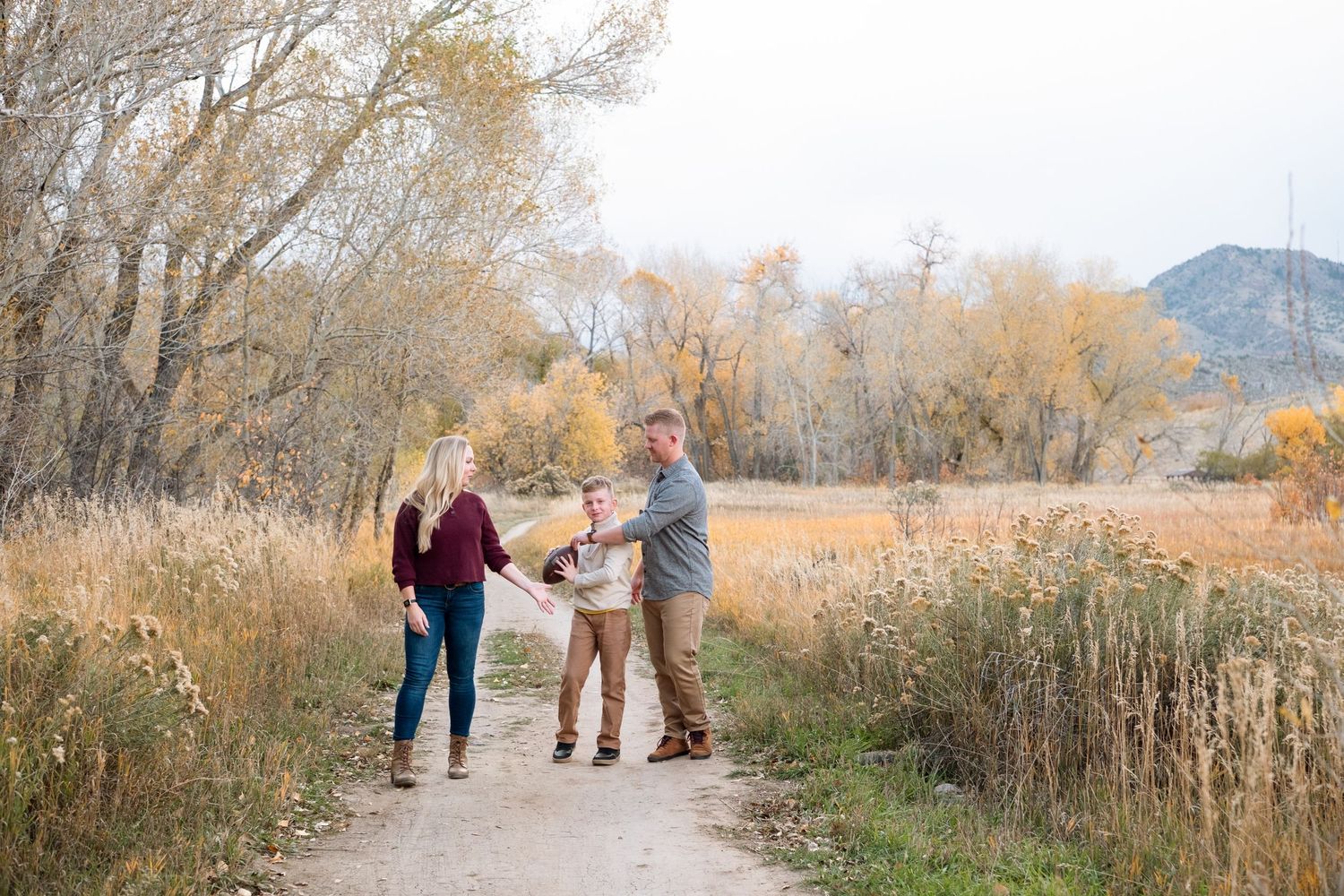 Family of three on walking path at Bear Creek Lake in Lakewood, Colorado.