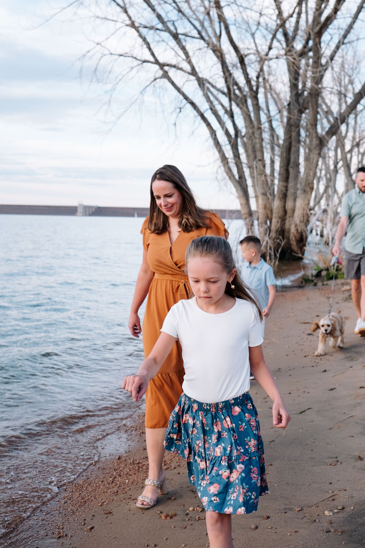 Family photo session at Chatfield State Park, candid of mother and daughter walking shoreline.