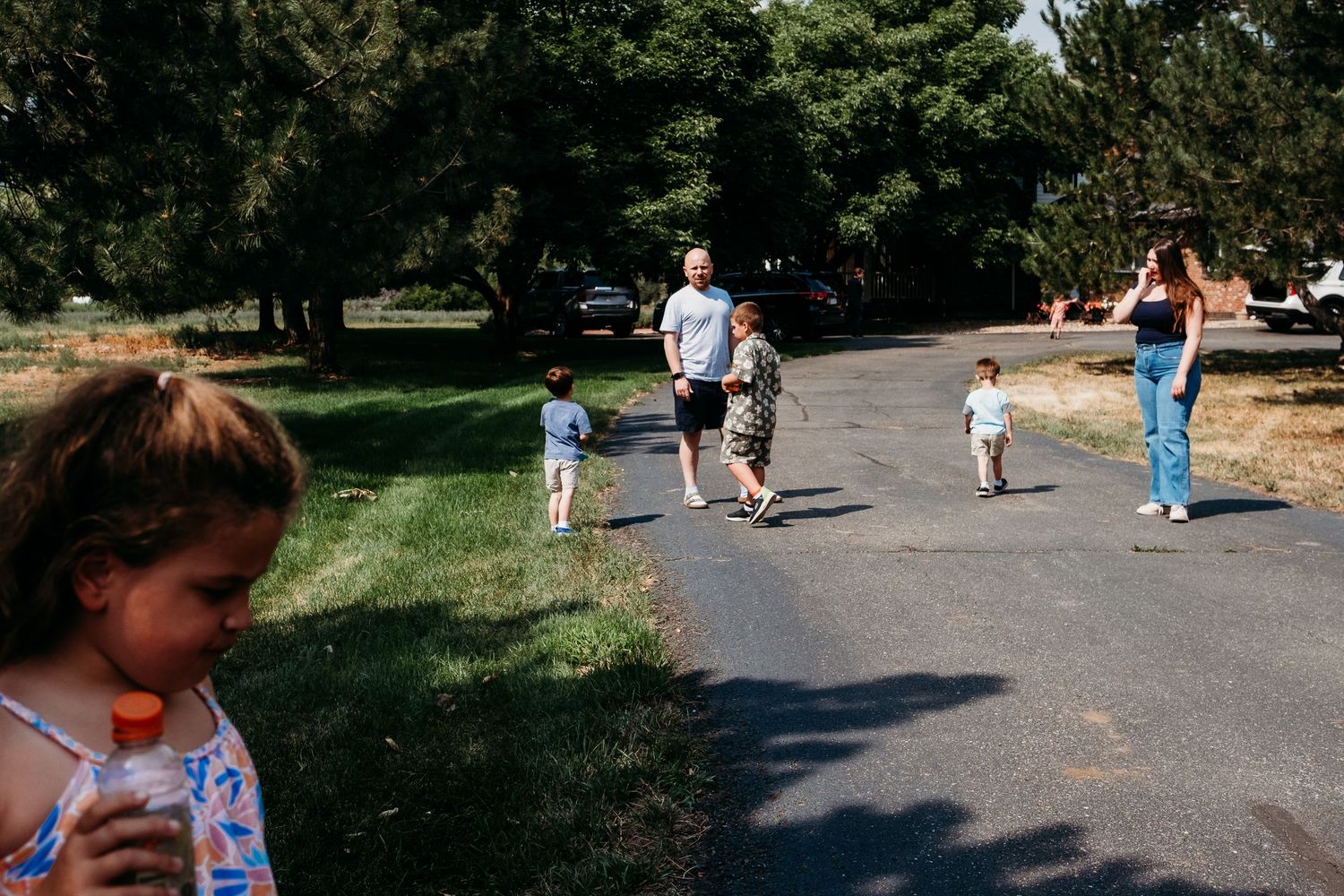 Documentary photo of several people walking on extended driveway in multi generation family photo session.