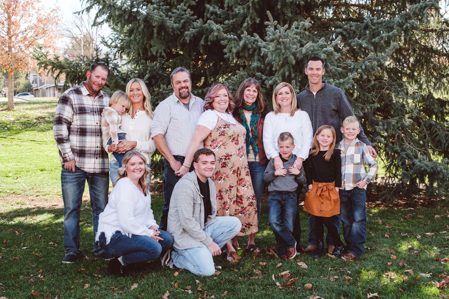 Extended family standing together, all smiling, in park in Centennial, Colorado.  Group includes grandmother, adult children and grandkids.