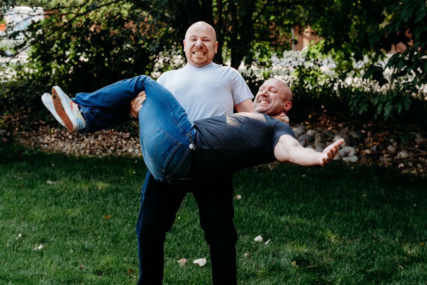 Adult brothers posed playfully, one brother holding another.
