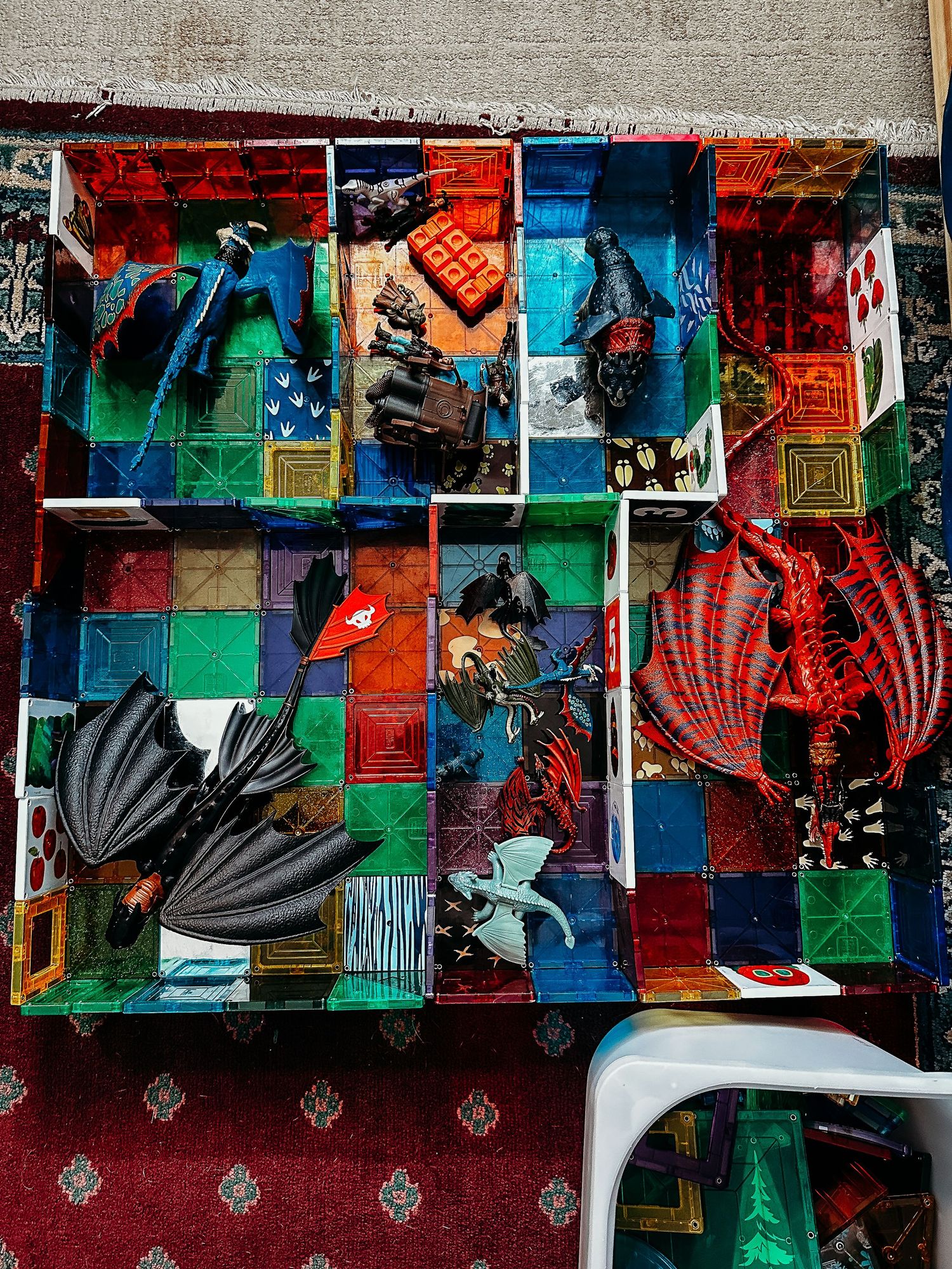 Colorful photo of magnatiles assembled as a pen for dragon figurines.