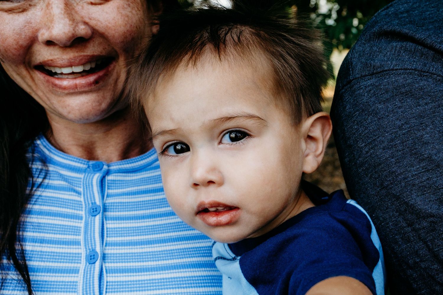 Close up of toddler boy, mother holding him.