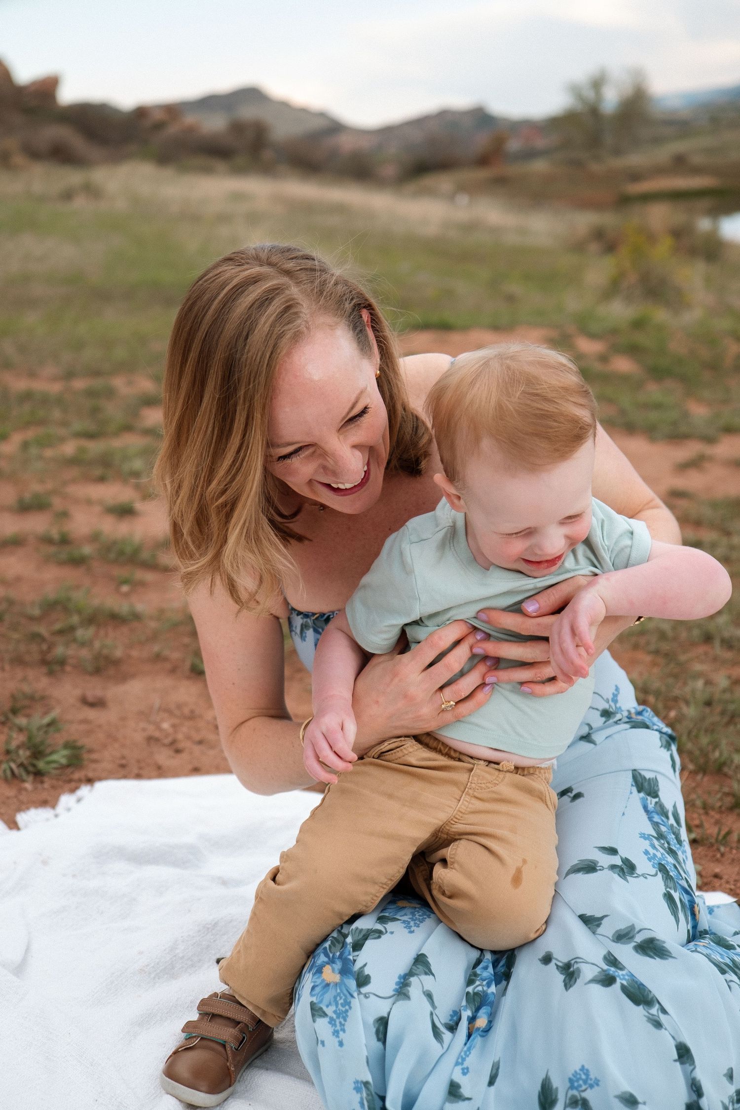 Mother holding tightly onto laughign toddler.