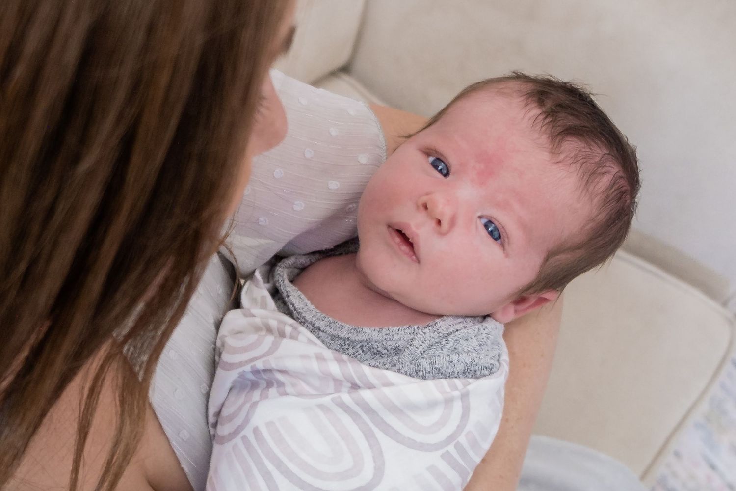 Mother holding calm newborn boy.
