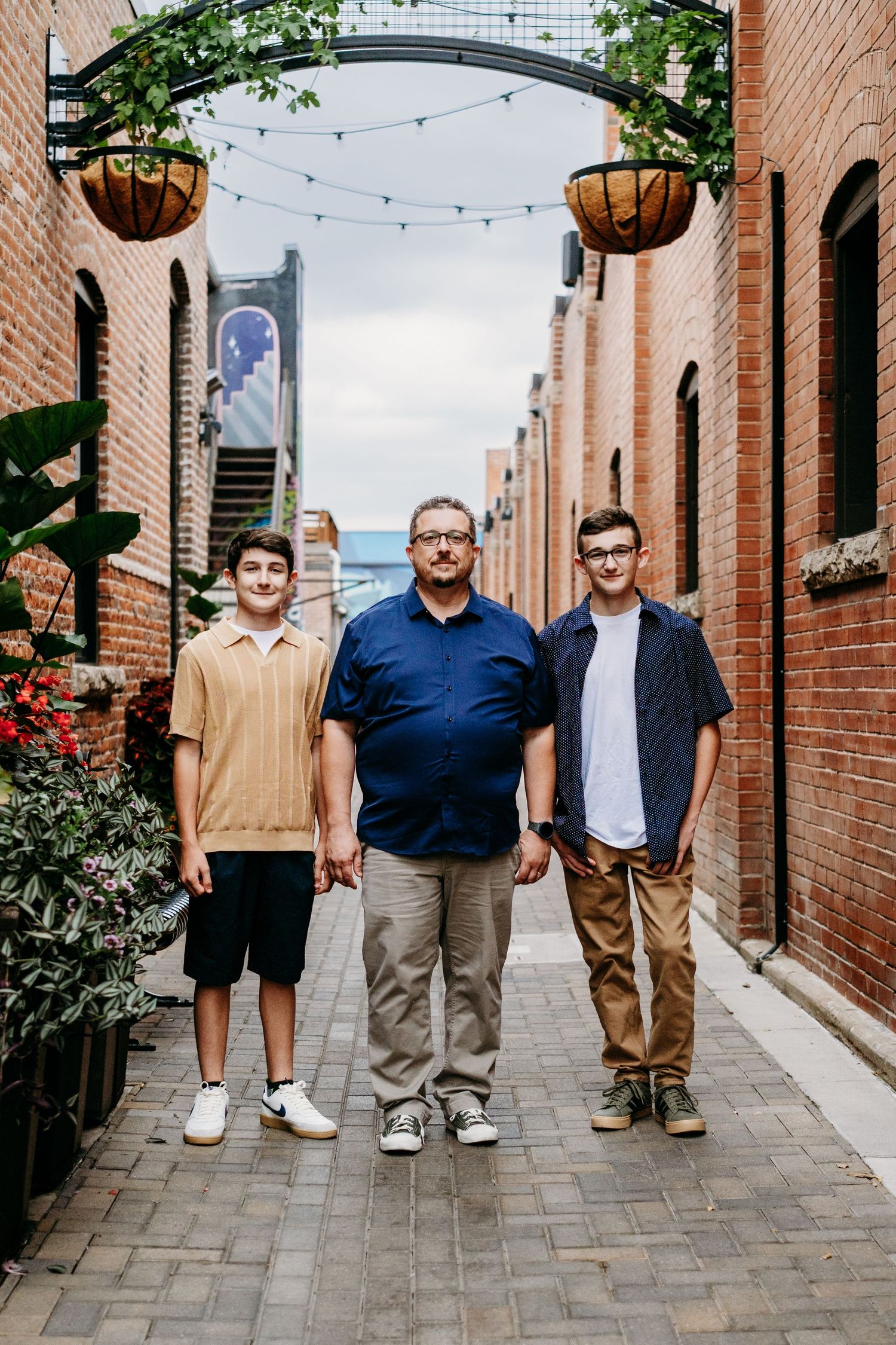 Father and two sons walking down alleyway in Downtown Fort Collins.