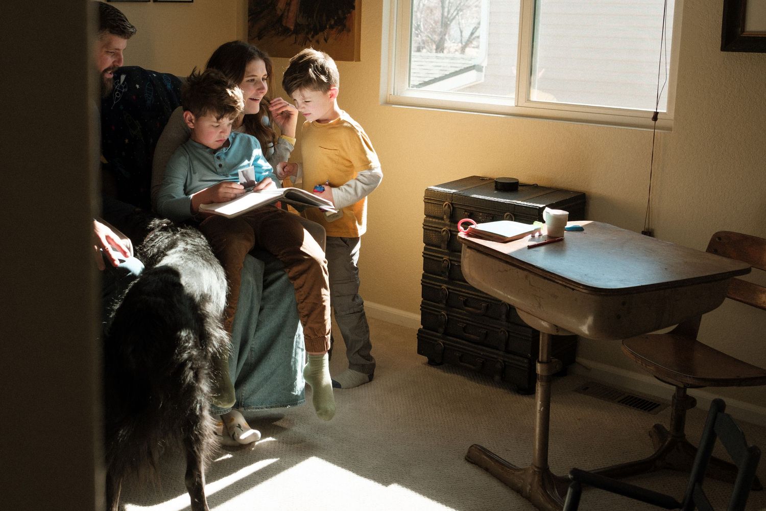 Quiet mooment of mother and father sitting in a room with dramatic shadows during documentary family photo session.