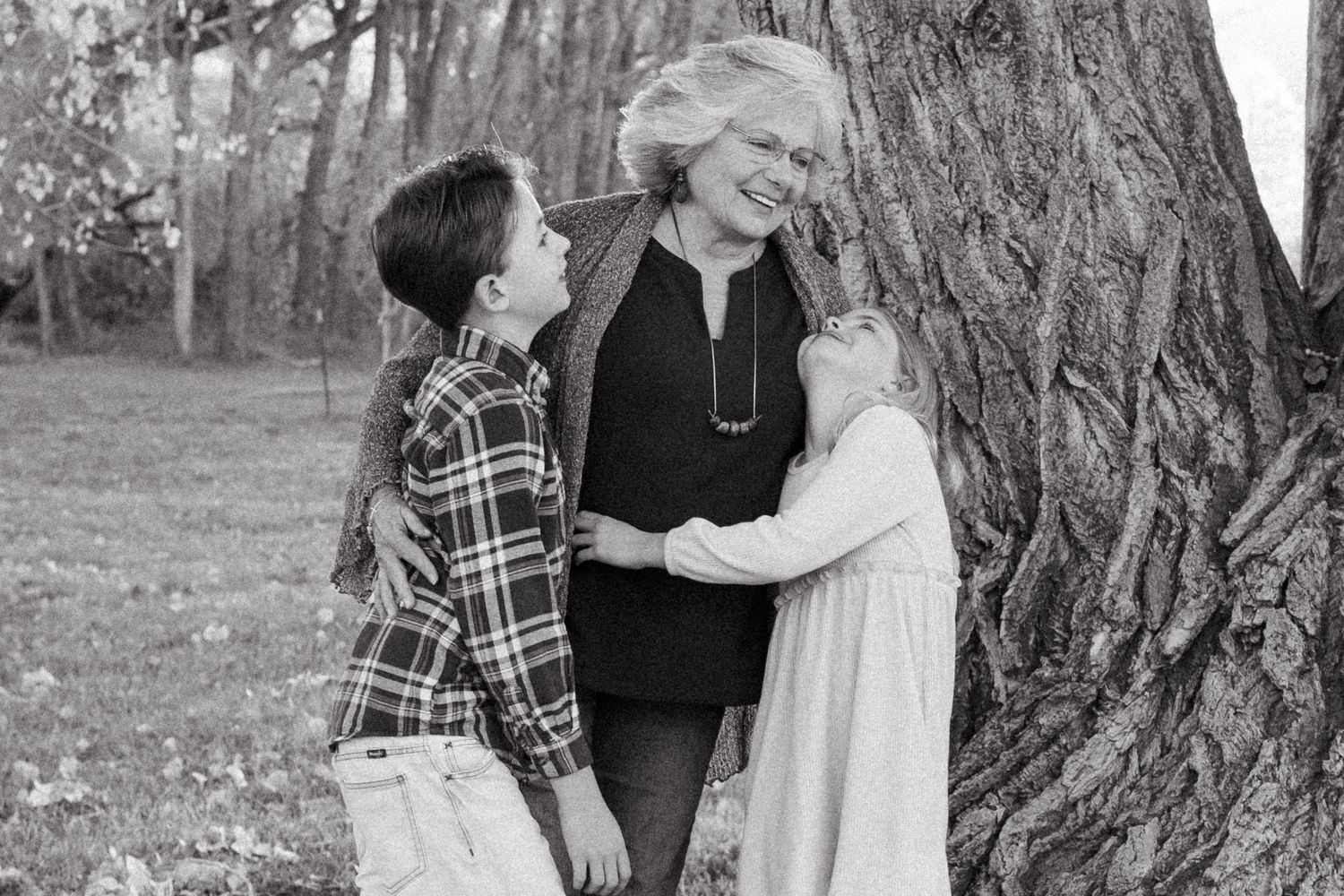 Black and white candid of grandmother laughing with two grandchildren.
