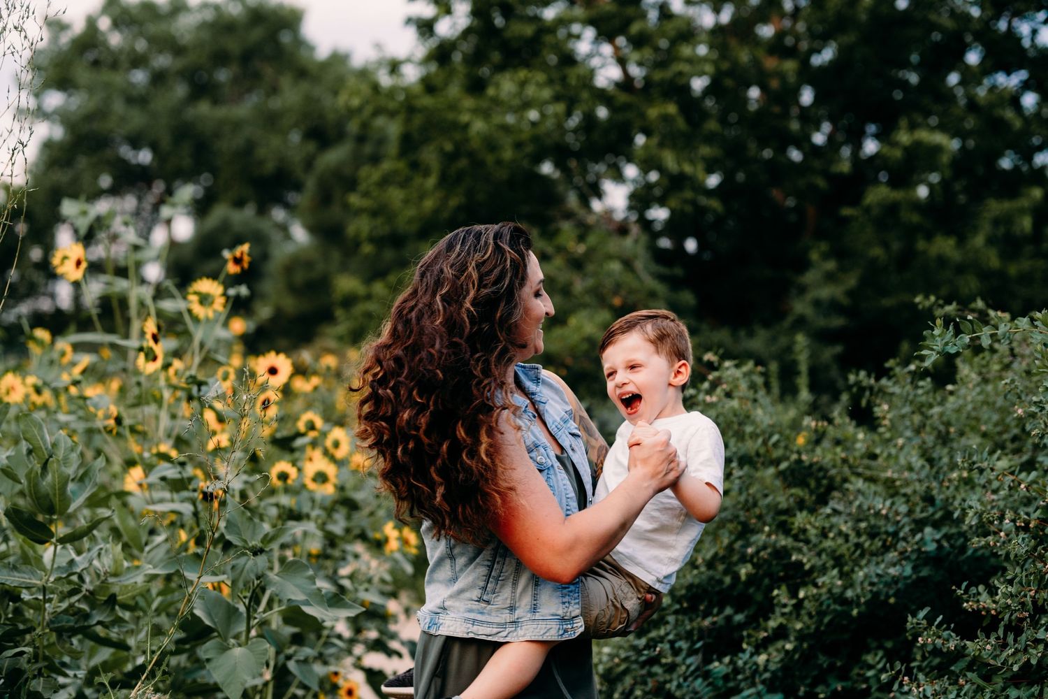 Mother playfully spinning son, son laughing, in garden at Majestic View Park in Arvada, Colorado.