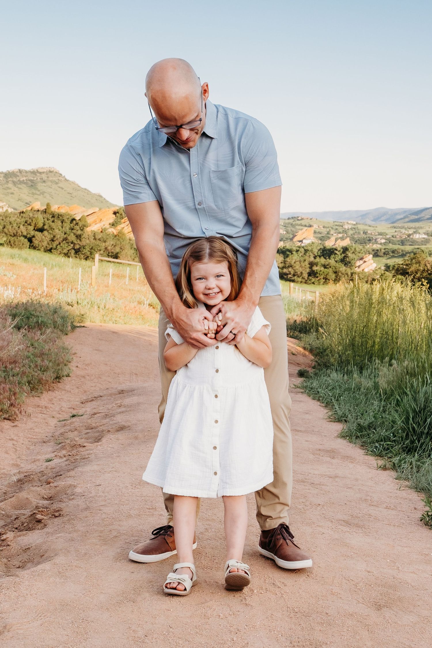Father playfully walking with daughter on trailhead at South Valley Park.