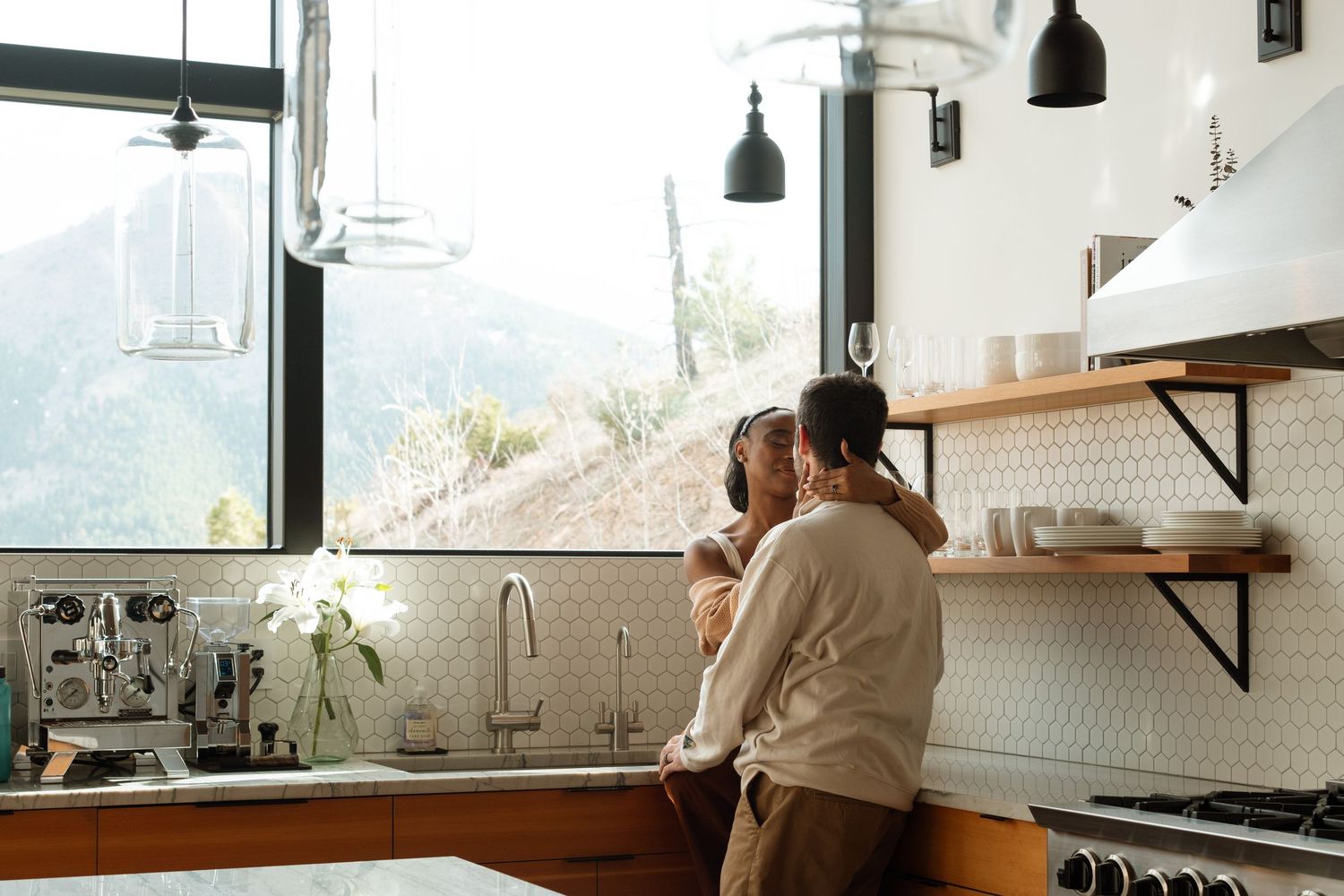 Pregnant couple embracing in modern kitchen during maternity photography session near Denver, Colorado.